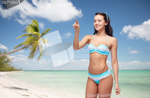 Image of happy woman in bikini swimsuit pointing finger