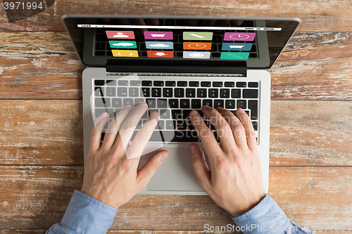 Image of close up of male hands with laptop typing