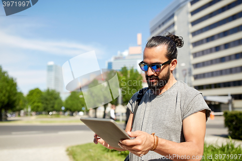 Image of man traveling with backpack and tablet pc in city