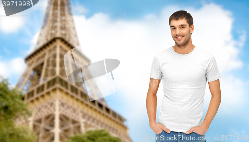 Image of happy man in blank white t-shirt over eiffel tower