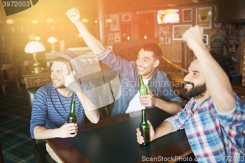 Image of happy male friends drinking beer at bar or pub