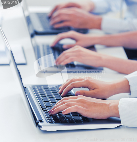 Image of group of people working with laptops in office