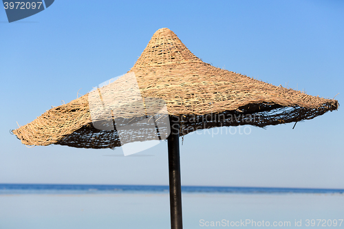 Image of Beach umbrella and blue sky background