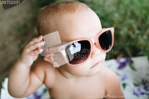 Image of Baby in big sunglasses on a river