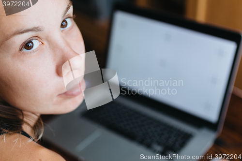 Image of Woman working on computer and looking at the camera