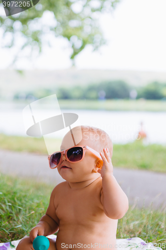 Image of Baby in big sunglasses on a river