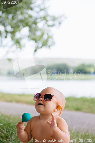 Image of Baby in big sunglasses on a river