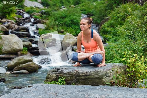 Image of Woman doing  Ashtanga Vinyasa Yoga  arm balance asana Tolasana