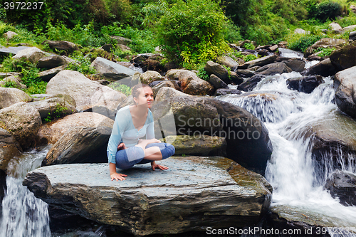 Image of Woman doing  Ashtanga Vinyasa Yoga  arm balance asana Tolasana