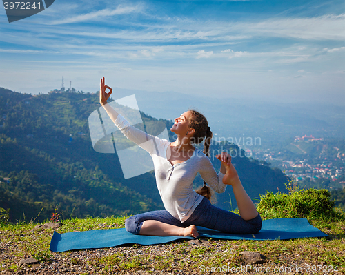 Image of Sorty fit woman doing yoga asana outdoors in mountains