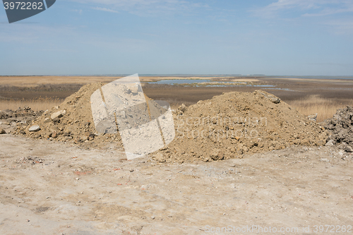 Image of Two heaps of earth with a small amount of construction waste