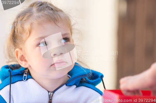 Image of Sad girl sitting at the table looked up