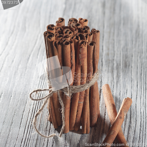 Image of Cinnamon sticks isolated on white wooden table