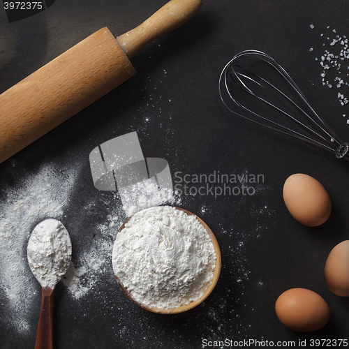 Image of flour and ingredients on black table