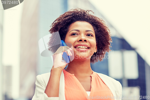 Image of happy african businesswoman calling on smartphone