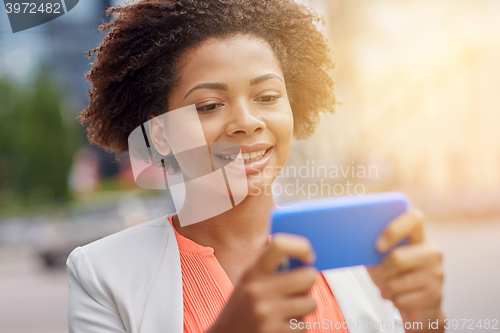 Image of happy african businesswoman with smartphone