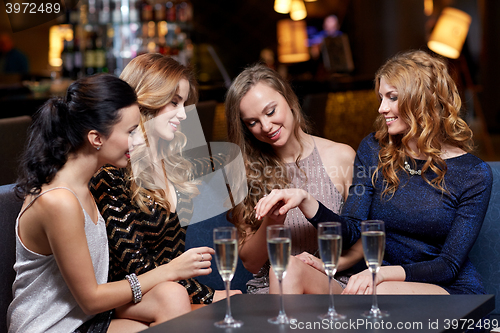 Image of woman showing engagement ring to her friends