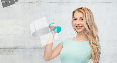 Image of smiling beautiful young sporty woman with dumbbell