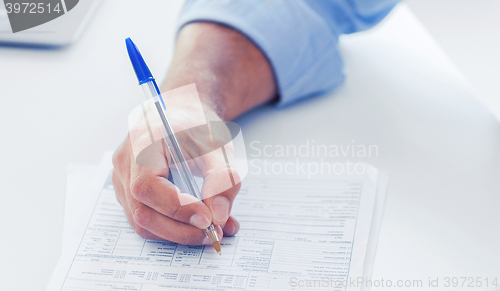 Image of man filling tax form