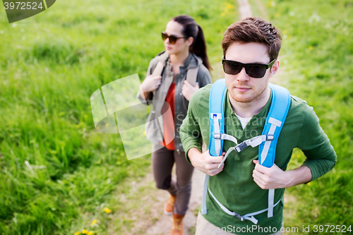 Image of couple with backpacks hiking outdoors