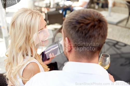 Image of happy couple with wallet paying bill at restaurant