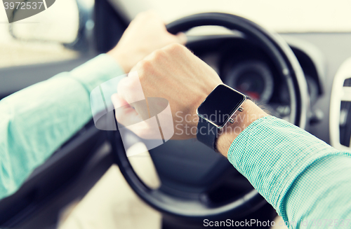 Image of close up of man with wristwatch driving car