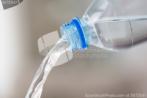 Image of close up of water pouring from plastic bottle