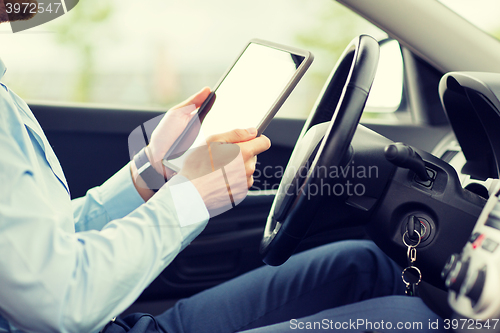 Image of close up of young man with tablet pc driving car