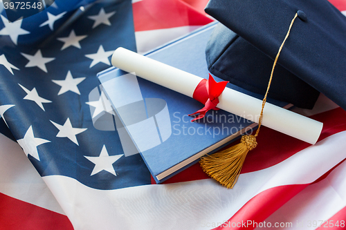 Image of bachelor hat and diploma on american flag