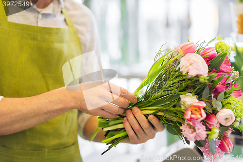 Image of close up of man making bunch at flower shop