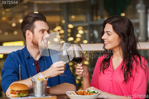 Image of happy couple dining and drink wine at restaurant
