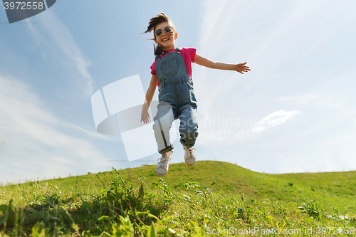 Image of happy little girl jumping high outdoors