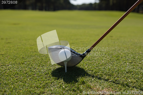 Image of golf player placing ball on tee