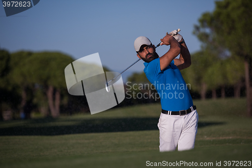 Image of pro golfer hitting a sand bunker shot