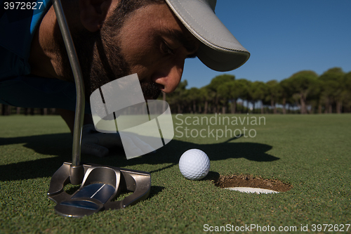 Image of golf player blowing ball in hole