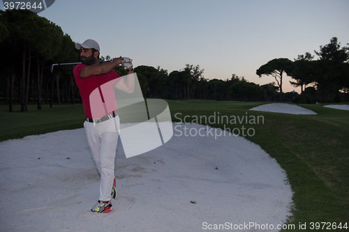 Image of golfer hitting a sand bunker shot on sunset