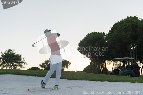 Image of golfer hitting a sand bunker shot on sunset