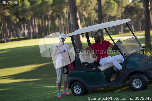 Image of couple in buggy on golf course