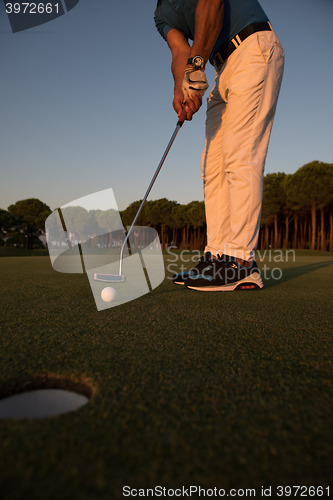 Image of golfer  hitting shot at golf course