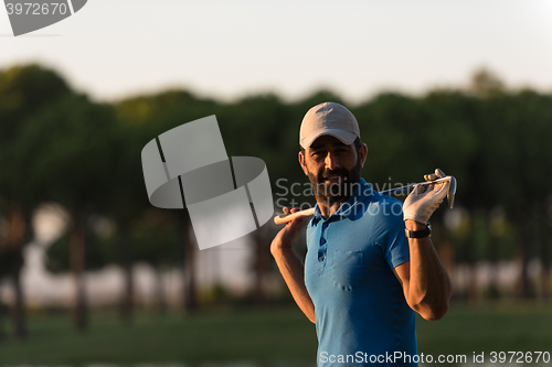 Image of golfer  portrait at golf course on sunset