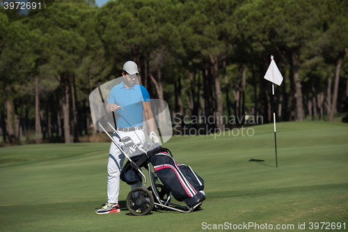 Image of golf player walking with wheel bag