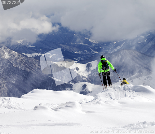 Image of Freeriders on off-piste slope and mountains in mist
