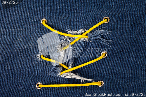 Image of Blue jean with hole and crisscross lacing