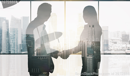 Image of business partners silhouettes making handshake