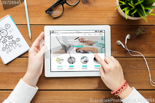 Image of close up of woman with tablet pc on wooden table