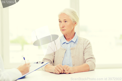 Image of doctor with clipboard and senior woman at hospital