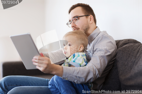 Image of father and son with tablet pc playing at home