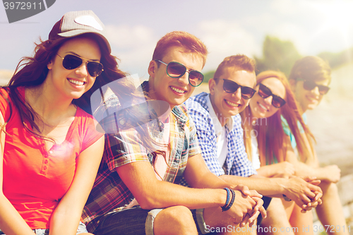 Image of close up of smiling friends sitting on city street