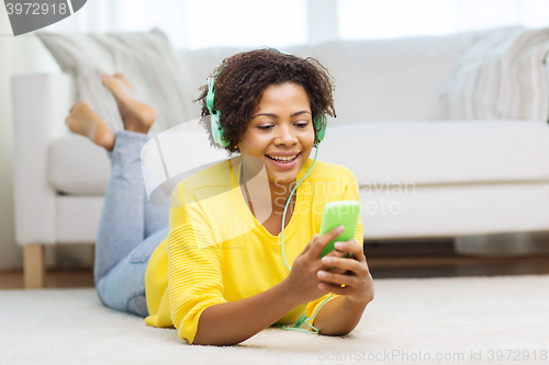 Image of happy african woman with smartphone and headphones