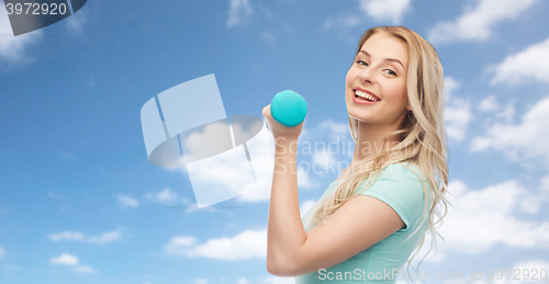 Image of smiling beautiful young sporty woman with dumbbell